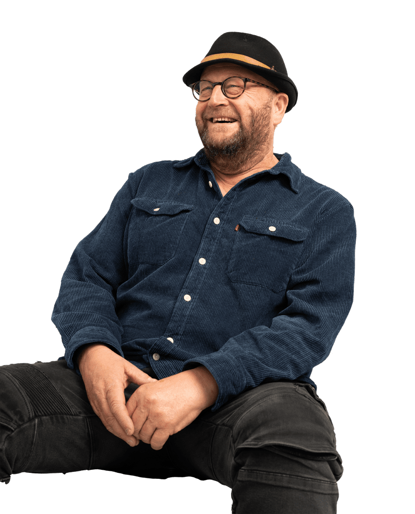 Londoner in blue top and black hat smiles off camera