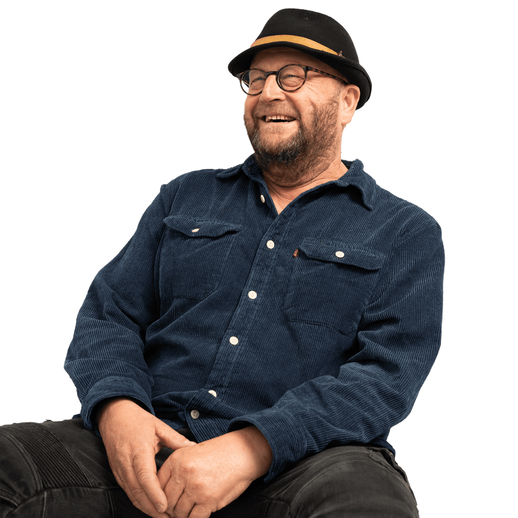 Londoner in blue top and black hat smiles off camera