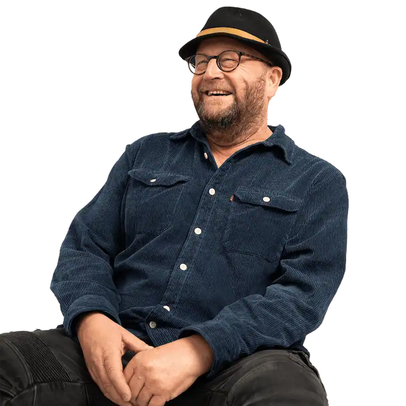 Londoner in blue top and black hat smiles off camera