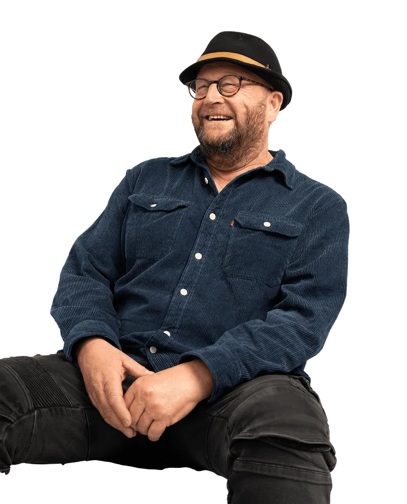 Londoner in blue top and black hat smiles off camera