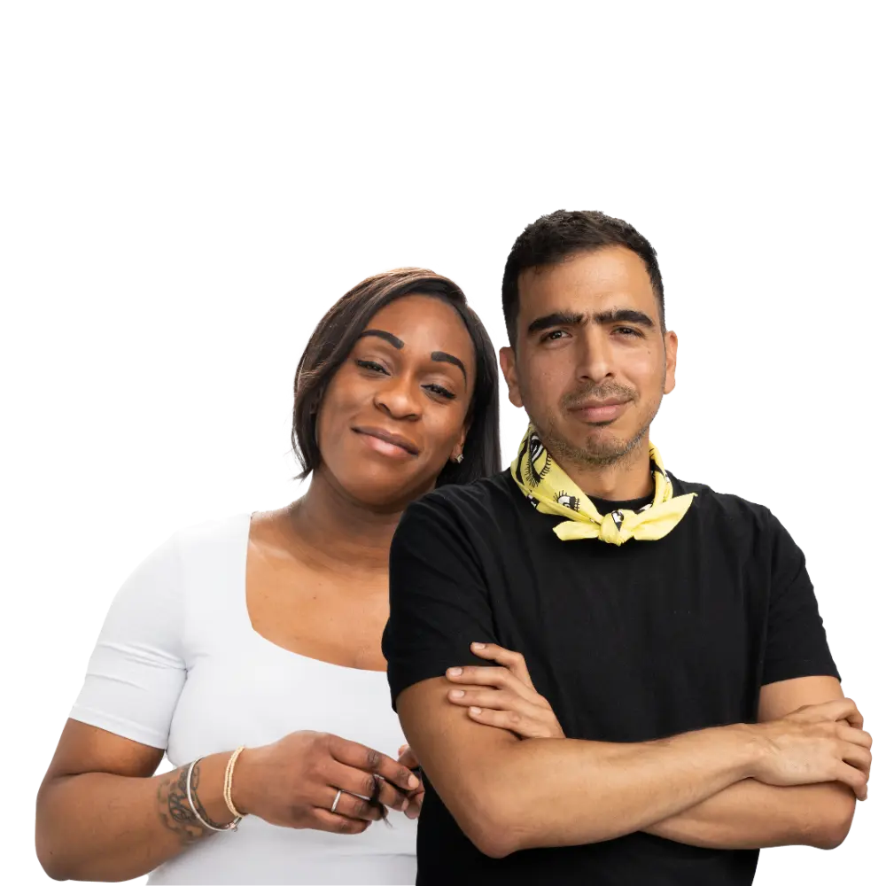 Two Londoners look into camera, one wearing a white top and one wearing a black top